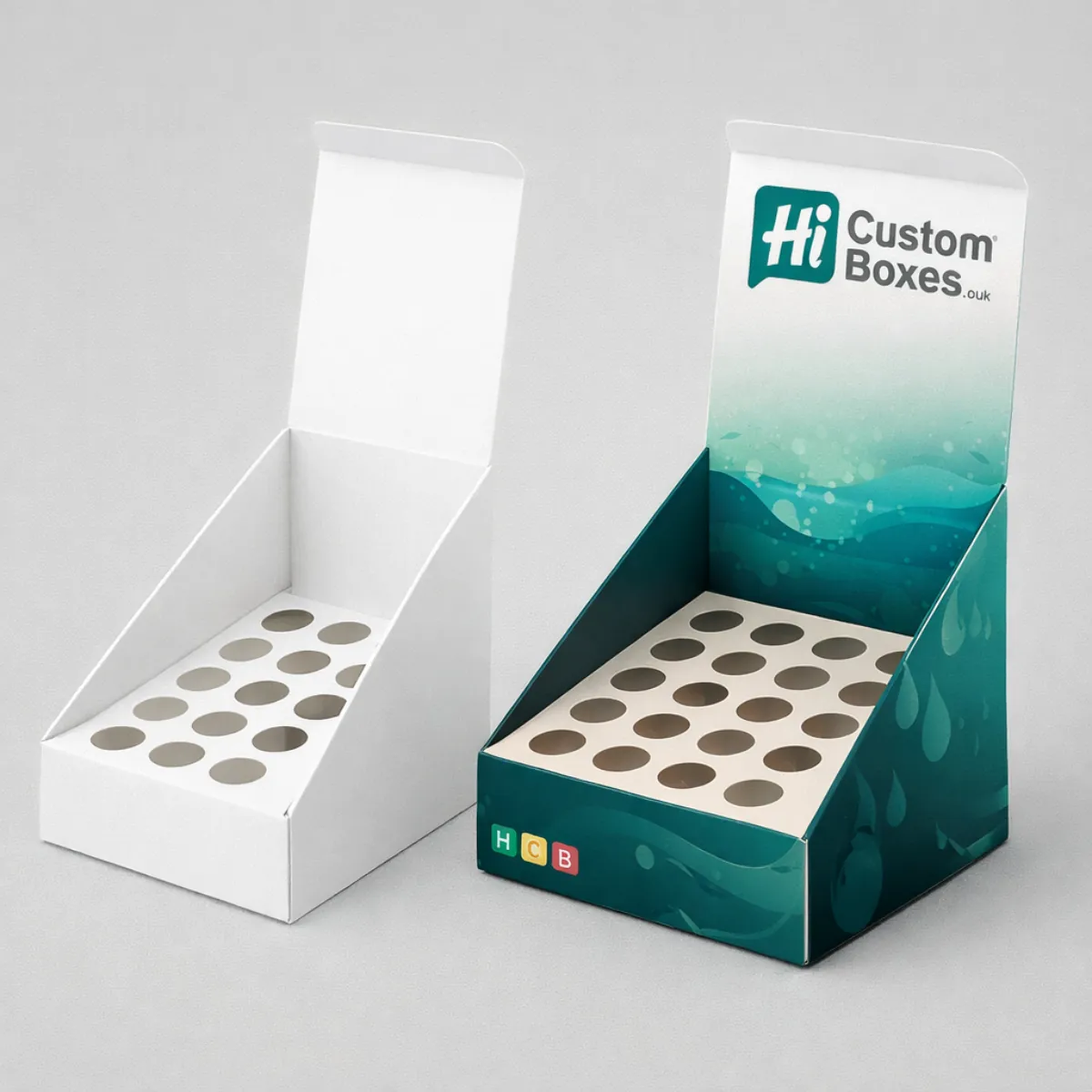 Empty cardboard counter-top display units featuring die-cut circular inserts to hold sixteen individual bottles securely- class=
